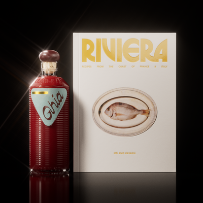 Ghia aperitif bottle beside the Riviera cookbook with a fish plate on its cream cover