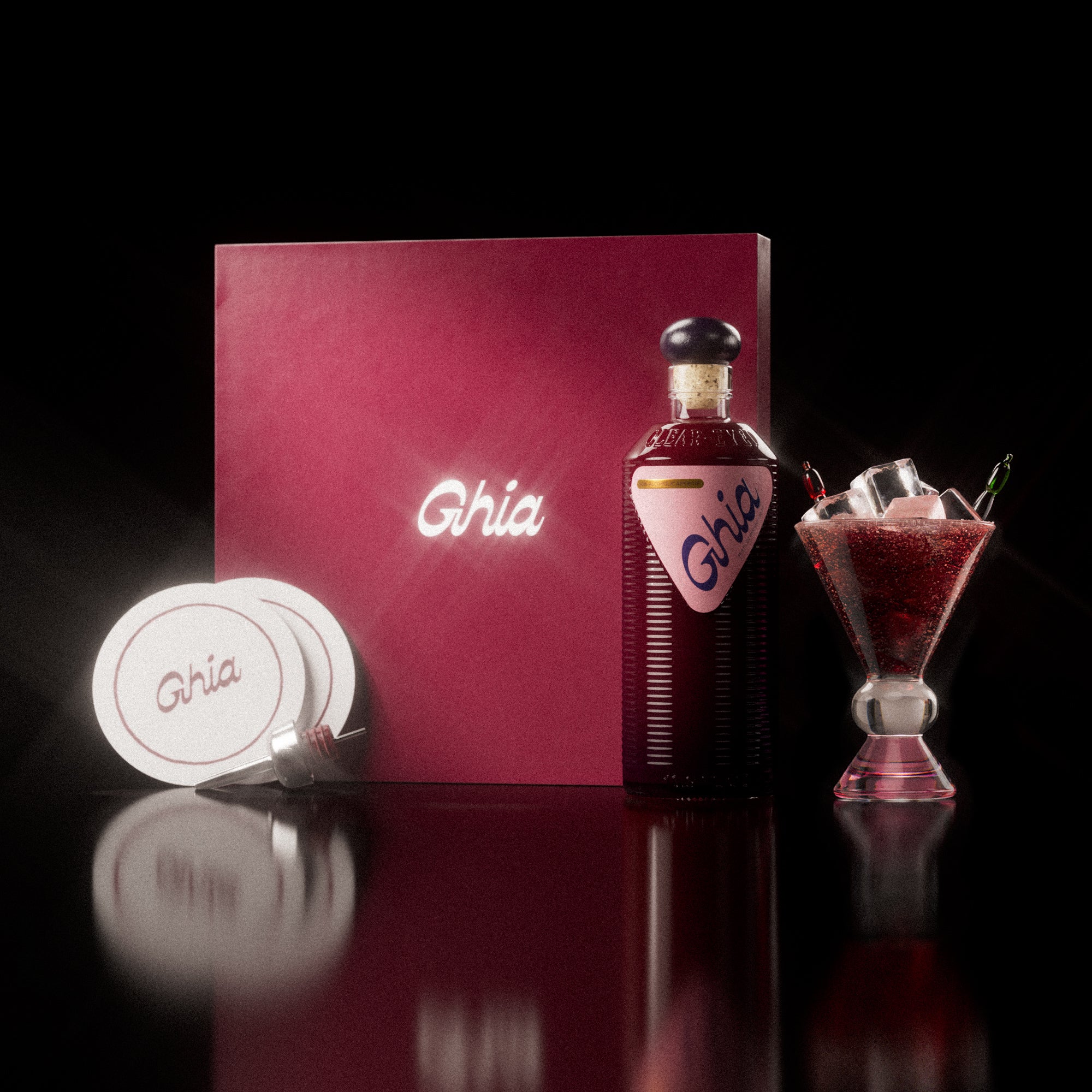 A Ghia non-alcoholic aperitif gift set with a burgundy box, paper coasters, 1 glass bottle of Berry Apéritif and a decorative cocktail glass that has a clear and pink base.