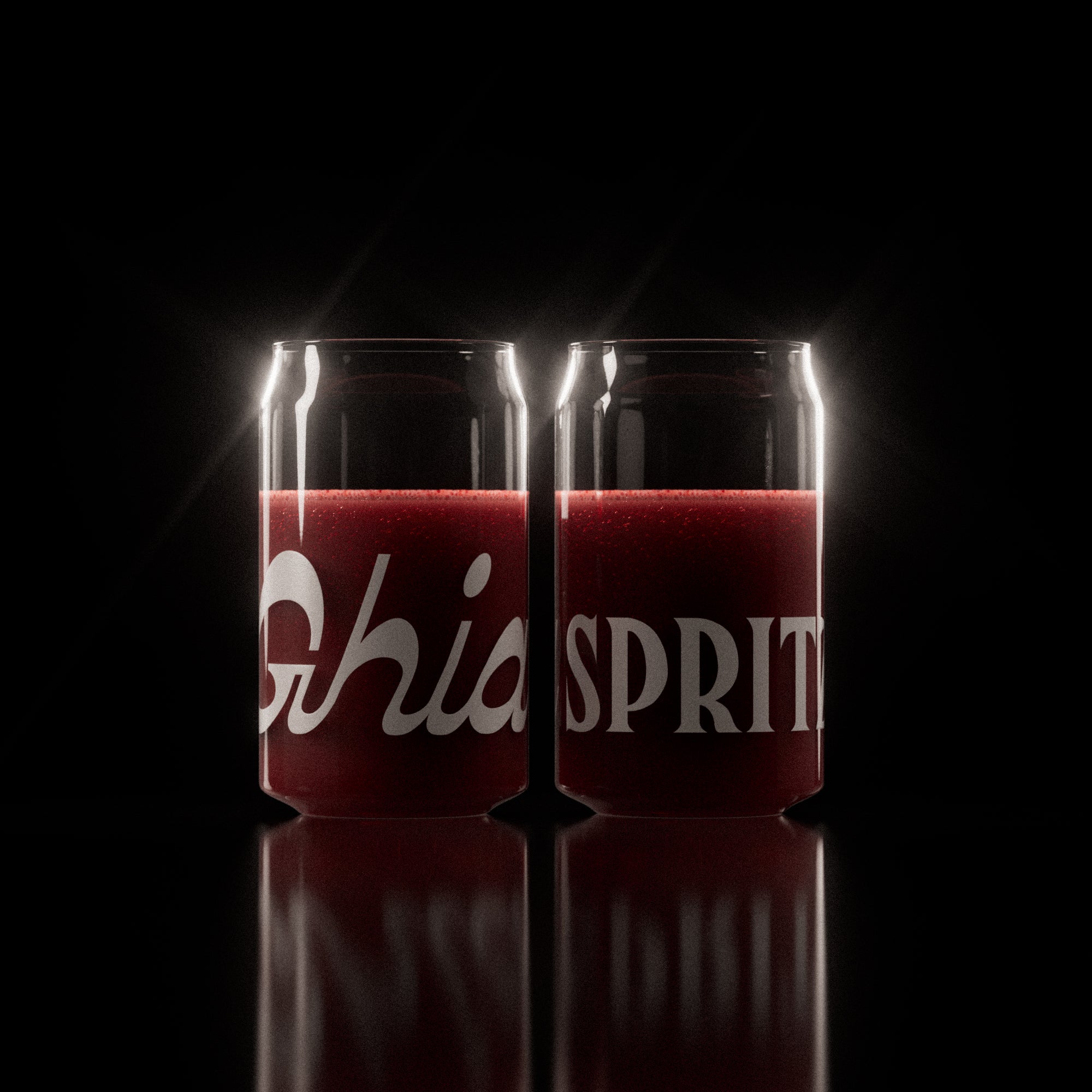 Two clear Ghia-branded glasses filled with a deep red sparkling beverage, featuring bold white lettering wrapping around the surface.